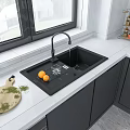 Modern Kitchen Black Sink With Running Faucet White Countertop Cutting Board Oranges And Gray Cabinets