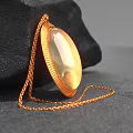 Decorative Jewelry Ornament Set With Gold Oval Shiny Pendant On Black Stone Background