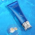 Blue Latitude Skincare Tube With White Flowers In Clear Container And Blue Water Ripple Background