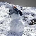 Outdoor Winter Snowman With Carrot Nose And Scarf On Snowy Ground
