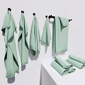 Light Green Towels Hanging On Hooks And Folded On White Countertop