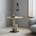 Modern Light Wood Side Table With Round Top Curved Legs Abstract Painting And Gray Sofa