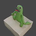 Green Plush Game Movie Character Sitting With Big Eyes Open Mouth And Teeth