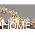 Welcome Home Letter Decorative Setup With Floral Arrangements And Brick Floor