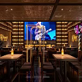 Bravo Bar Interior With Big Screen Live Music Tables Chairs And Wine Bottles