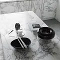 Elegant Decorative Ornament Set with Black Bowl Silver Utensils Transparent Lidded Container on Marble Countertop