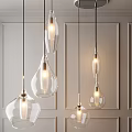 Multiple Illuminated Glass Pendant Lights Hanging In Modern Interior With Neutral Wall Background