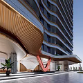 Modern High Rise Building Entrance With Red V Shape Accent Green Plants And Stone Pathway