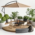 Outdoor Chairs With Fire Pit Under Patio Umbrella On Wooden Deck Surrounded By Green Plants