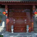 Traditional Chinese Style Red Entrance Gate With Carved Decorations Red Lanterns And Bamboo Plants