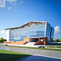 Modern School Building With Glass Facade Sloped Roof And Green Lawns By Road