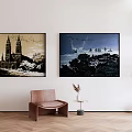 Stylish Interior Featuring Two Wall Paintings Brown Chair Side Table And Green Plant