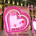 Outdoor Night Display With Large Pink Letters And Heart Shaped Structure