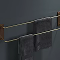 Modern Bathroom Towel Rack With Wooden Brackets And Golden Bars Holding Gray Towels