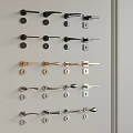 Various Styles and Colors of Door Handles Arranged on Gray Wall