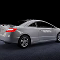 Silver Honda Two Door Coupe With Sleek Lines And Silver Wheels On Gray Carpet