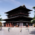 Ancient Multi story Traditional Building With Classic Roof Surrounded By Trees And People