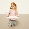 Young Blonde Girl With Pigtails Drawing On Paper Using Red Pencil On Light Colored Carpet