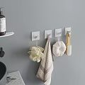 Stylish Bathroom Accessories on Gray Wall with White Hooks Bath Sponge Towel and Wooden Brush