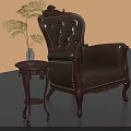 Antique Leather Armchair With Carved Details And Wooden Side Table With Green Plant