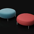 Two Round Upholstered Footstools in Blue and Red with Metal Legs on Black Background