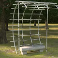 Modern Outdoor Metal Arched Structure With Stone Bench Grass And Trees