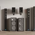 Collection of Various Floor Standing and Wall Mounted Audio Speakers Displayed Against Wall