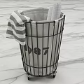 Storage Basket With Black Metal Frame Wheels Gray Liner And Striped Towel On Marble Floor