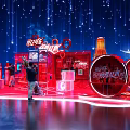 Coca Cola Exhibition Booth Red Themed Design With Large Bottle Models And Visitors