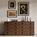 Brown Wooden Cabinet With Multiple Drawers And Framed Artworks Books Vases And Mirror On Top