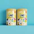 GOS Infant Formula Milk Powder In Yellow Cans With Cartoon Cow On Light Blue Background