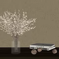 Clear Glass Vase With White Decorative Branches And White Book On Light Gray Wall
