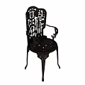 Ornate Metal Chair With Intricate Carved Patterns And Decorative Armrests