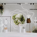 Stylish Fashion Clothing Store Window Display With Mannequins Green Plants Statues And Lighting Accents