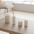 Lit White Candles on Wooden Table in Bright Room with Soft Lighting
