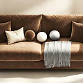 Cozy Brown Two Seater Sofa With Decorative Pillows Balls And Gray Blanket