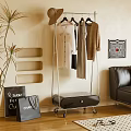 Modern Wheeled Clothes Rack With Hanging Shirts And Coats In Living Room With Sofa Plant