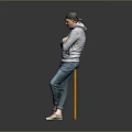 A Man In Gray Hoodie And Blue Jeans Leaning On Yellow Railing With Gray Background