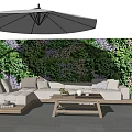 Outdoor Sofa With Wooden Coffee Table And Umbrella Against Greenery Wall With Purple Flowers