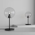 Two Modern Minimalist Table Lamps With Glass Globe Shade And Black Base On White Shelf