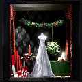 Festive Shop Window Display With Wedding Dress Christmas Wreath Green Plant Red Candles And Gifts