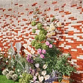 Garden Landscape With Red Brick Wall Green Plants Flowers Wooden Fence And Pebble Ground