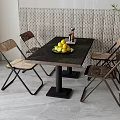 Modern Dining Table Set With Black Tabletop Four Woven Chairs And Yellow Fruits Bowl