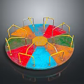 Colorful Children's Playground Carousel With Circular Design Red Blue Green Orange Sections And Yellow Handrails