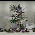 Decorative Floral Installation With Transparent Cylindrical Stands And Purple Pink White Flowers