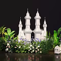 Lush Green Plant Wall Featuring Palm Leaves White Castle Model And Flowers With White Lanterns
