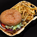 Sesame Bun Hamburger With Lettuce Purple Cabbage Sauce And Crispy French Fries In Paper Basket