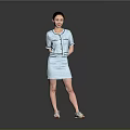 Woman in light blue short sleeve suit dress standing on gray background wearing white shoes