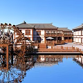 Traditional Style Homestay Building By Water With Large Wooden Waterwheel And Reflection