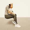 Mother and Child Sitting Together on Beige Floor in Casual Outfits with Sneakers